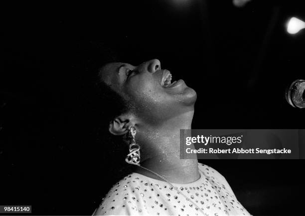 Singer Aretha Franklin tilts her head back in a joyful pose, while singing and playing the piano during a concert at Chicago's Cook County Jail,...