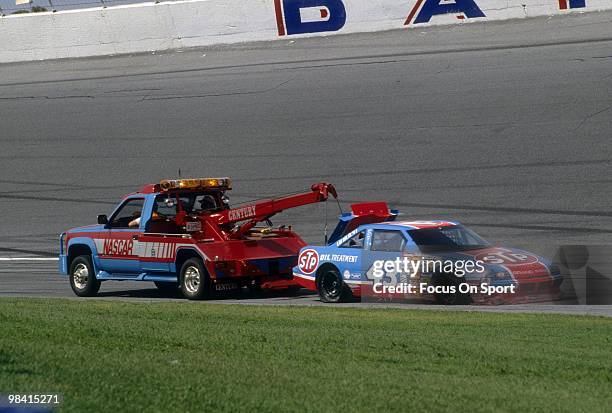 Richard Petty's STP car is being towed off the track February 18, 1990 during the Nascar Winston Cup Daytona 500 at Daytona International Speedway in...