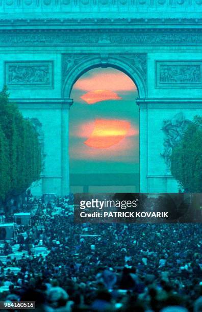 An estimated 200,000 people gather on the Champs Elysees in Paris late 10 May 1994 to watch the annular eclipse through the Arch de Triomphe despite...