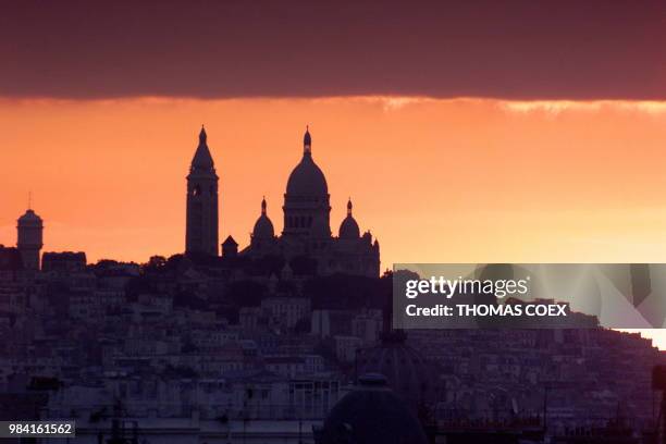 Lever du soleil sur le Sacré-Coeur de Montmartre à Paris, le 23 juillet 1999. AFP PHOTO THOMAS COEX