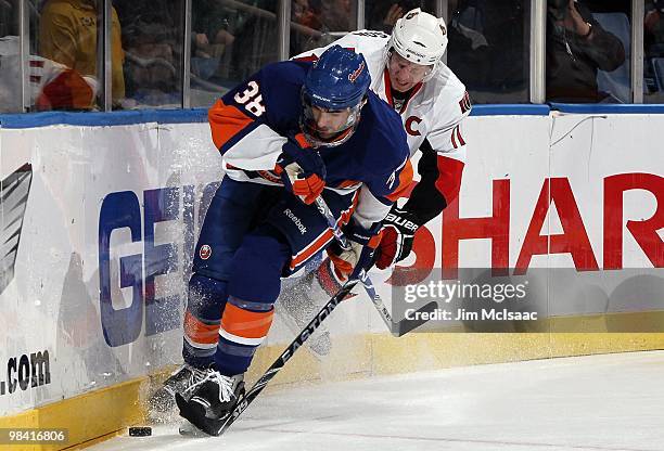 Jack Hillen of the New York Islanders skates against Daniel Alfredsson of the Ottawa Senators on April 3, 2010 at Nassau Coliseum in Uniondale, New...