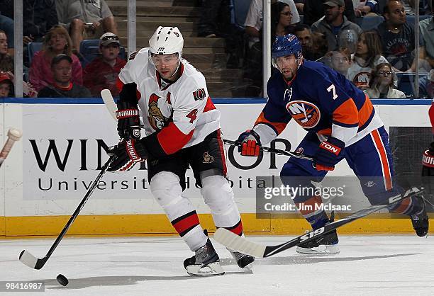 Chris Phillips of the Ottawa Senators skates against Trent Hunter of the New York Islanders on April 3, 2010 at Nassau Coliseum in Uniondale, New...