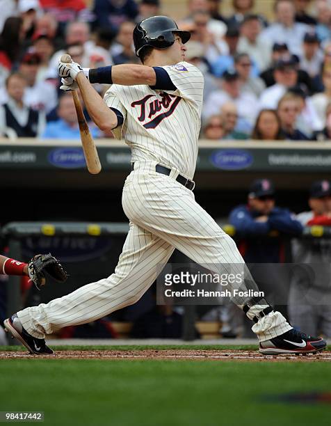 Joe Mauer of the Minnesota Twins hits an RBI double in the second inning against the Boston Red Sox during the Twins home opener at Target Field on...