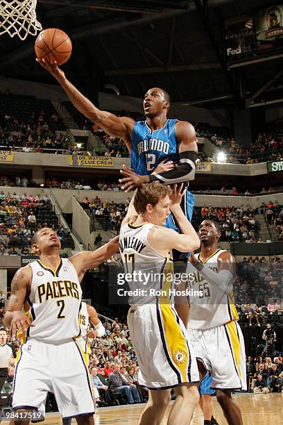 Dwight Howard of the Orlando Magic shoots over Mike Dunleavy, Earl Watson and Roy Hibbert of the Indiana Pacers at Conseco Fieldhouse on April 12,...