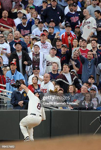 Nick Punto of the Minnesota Twins makes a catch in foul territory for the second out of the ninth inning against the Boston Red Sox during the Twins...