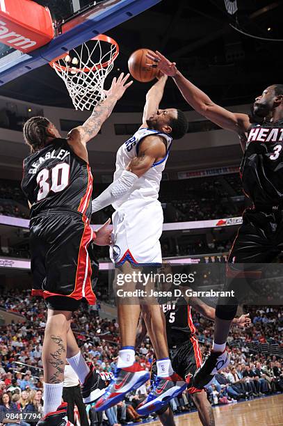 Andre Iguodala of the Philadelphia 76ers shoots against Michael Beasley and Dwyane Wade of the Miami Heat during the game on April 12, 2010 at the...