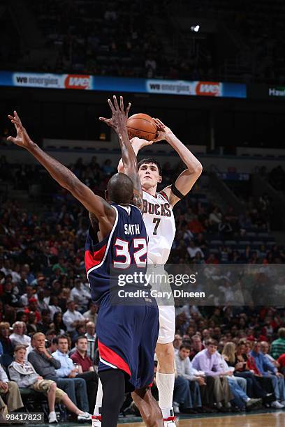 Ersan Ilyasova of the Milwaukee Bucks shoots a jumpshot against Joe Smith of the Atlanta Hawks on April 12, 2010 at the Bradley Center in Milwaukee,...