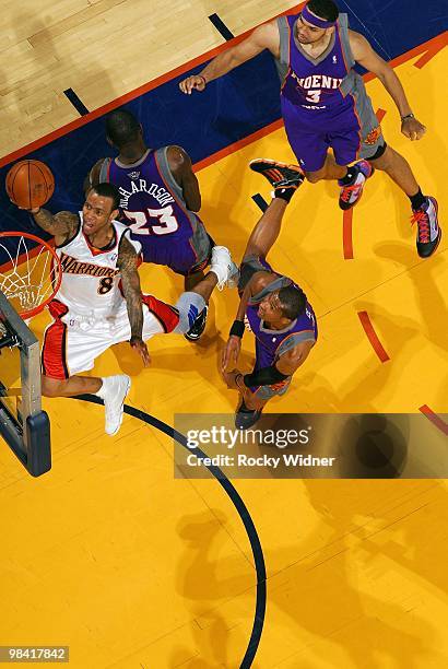 Monta Ellis of the Golden State Warriors shoots a layup against Jason Richardson, Leandro Barbosa and Jared Dudley of the Phoenix Suns during the...