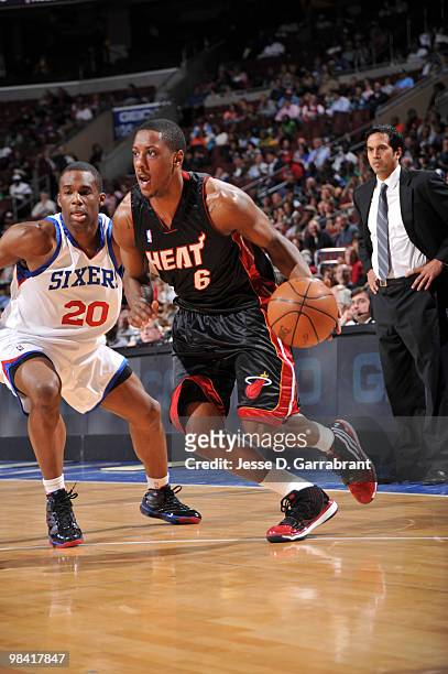 Mario Chalmers of the Miami Heat drives against Jodie Meeks of the Philadelphia 76ers during the game on April 12, 2010 at the Wachovia Center in...
