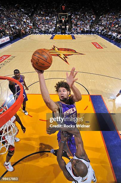 Robin Lopez of the Phoenix Suns goes up for a shot against Anthony Tolliver of the Golden State Warriors during the game at Oracle Arena on March 22,...