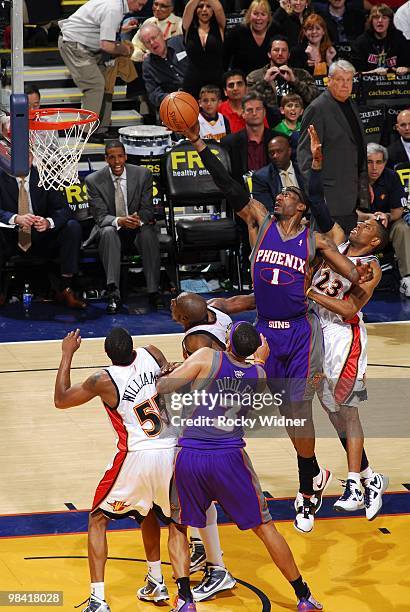 Amar'e Stoudemire of the Phoenix Suns shoots a layup against Reggie Williams, Anthony Tolliver and C.J. Watson of the Golden State Warriors during...