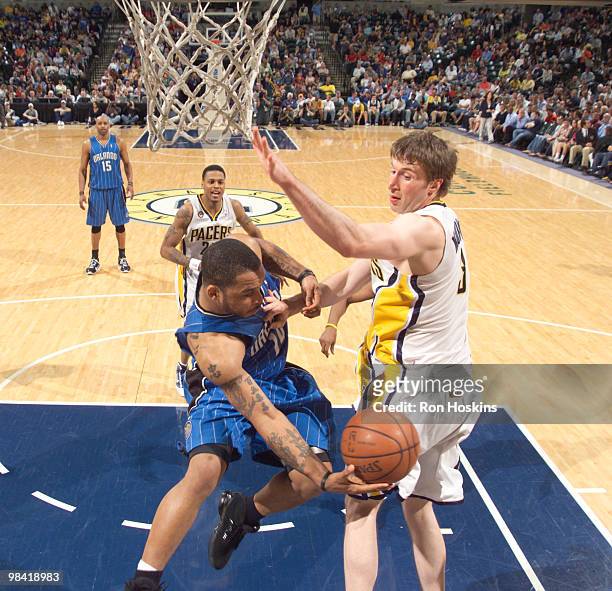 Jameer Nelson of the Orlando Magic passes the ball around Troy Murphy of the Indiana Pacers at Conseco Fieldhouse on April 12, 2010 in Indianapolis,...