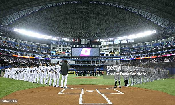The Toronto Blue Jays and Chicago White Sox stand during the national anthems prior to the White Sox facing the Toronto Blue Jays during their MLB...