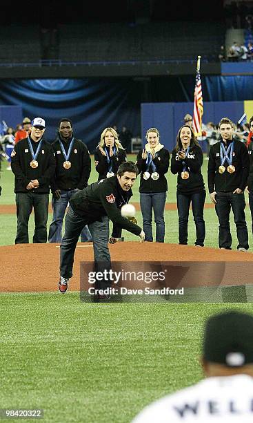 Canadian Olympic goal medalist Alex Bilodeau throws the ceremonial pitch to Vernon Wells of the Toronto Blue Jays prior to facing the Chicago White...