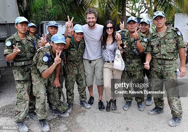 Actors Demi Moore and Gerard Butler pose with a group of Japanese UN soldiers during a visit to a camp for internally displaced persons managed by...