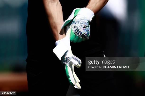 Japan's goalkeeper Eiji Kawashima puts on his gloves during a training session of Japan's national football team in Kazan on June 26, 2018 during the...