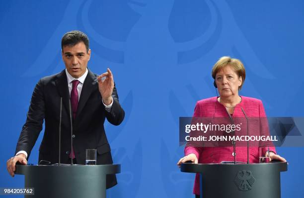 German Chancellor Angela Merkel and Spanish Prime Minister Pedro Sanchez address a press conference after bilateral talks at the Chancellery on June...