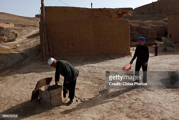Farmer lifts up water from a cistern in his yard on March 12, 2010 in Xihaigu, Tongxin County of Ningxia Hui Autonomous Region, north China. Xihaigu...