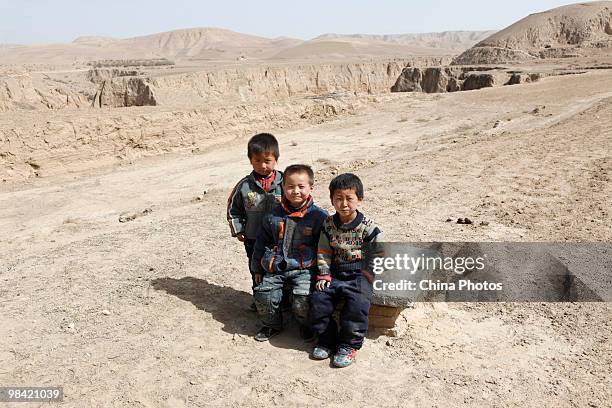 Children sit on the cover of a cistern on March 12, 2010 in Xihaigu, Tongxin County of Ningxia Hui Autonomous Region, north China. Xihaigu is the...