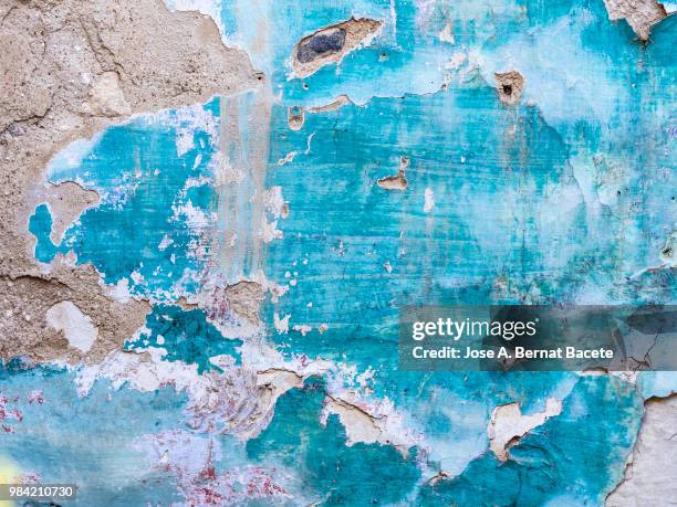 wall with peeling blue and white paint with cracks and dampness. - adobe texture stockfoto's en -beelden