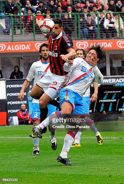Sebastian Alvarez of Catania competes with Marco Borriello of Milan during the Serie A match between AC Milan and Catania Calcio at Stadio Giuseppe...