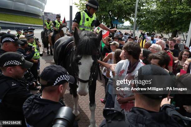 Police horses form a barrier between protestors and the entrance to the Undersea Defence Technology conference, organised by the Sink the Arms Fair...