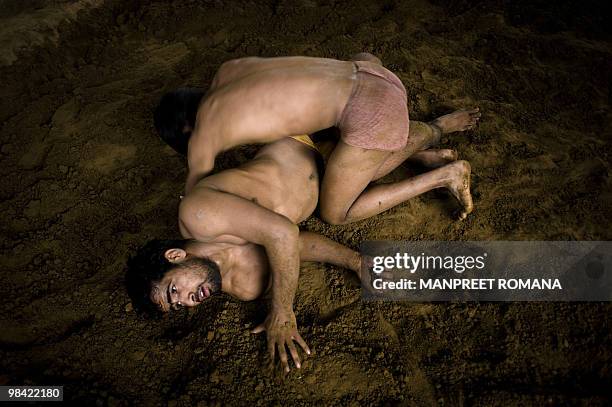 To go with AFP story by Kuldip Lal: WRESTLING-IND-CGAMES-2010 Indian wrestlers practice in a mud pit during a training session at Guru Hanuman Akhara...