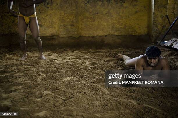 To go with AFP story by Kuldip Lal: WRESTLING-IND-CGAMES-2010 An Indian wrestler relaxes after a training session at Guru Hanuman Akhara in New Delhi...