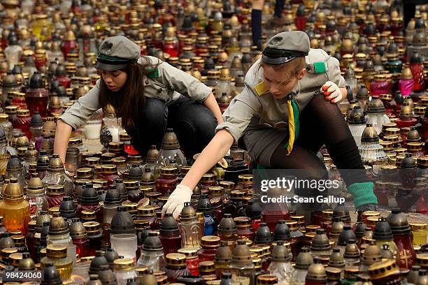 Polish girl scouts arrange candles left by mourners outside the Presidential Palace in memory of late Polish President Lech Kaczynski on April 13,...