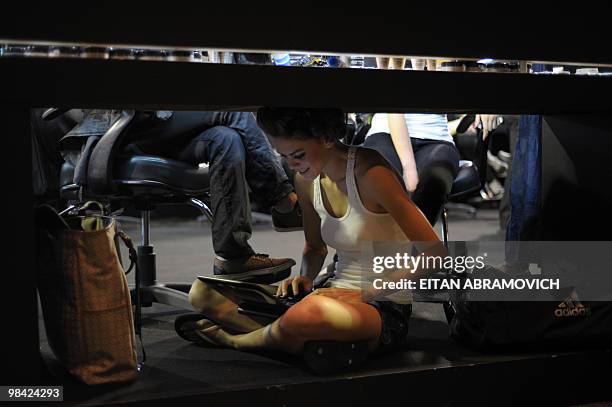Model works on her laptop backstage before hitting the catwalk to present a collection by Dominican designer Oscar de la Renta during the Cali...