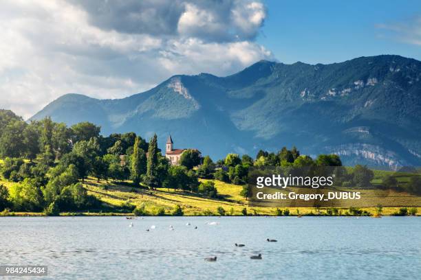 french landscape with small church steeple along rhone river and grand colombier bugey alps mountains in summer in auvergne-rhone-alpes - french imagens e fotografias de stock