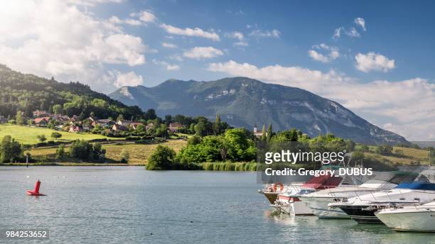 beautiful marina harbor on rhone river with recreational boats with small french village and church in middle of bugey alps mountains - rhone river stock pictures, royalty-free photos & images