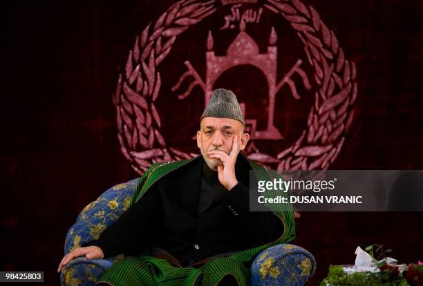 In this April 11, 2010 photograph, Afghan President Hamid Karzai listens to local elders in Kunduz, Afghanistan. Karzai urged Taliban insurgents to...