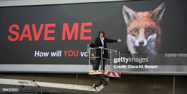 Former musician with the band Queen Brian May poses in front of a giant billboard as he launches the 'Save Me' Campaign in West London on April 13,...