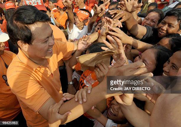 Philippine presidential candidate Senator Manny Villar meets with supporters as he walks through a public market in in Caloocan City suburban Manila...