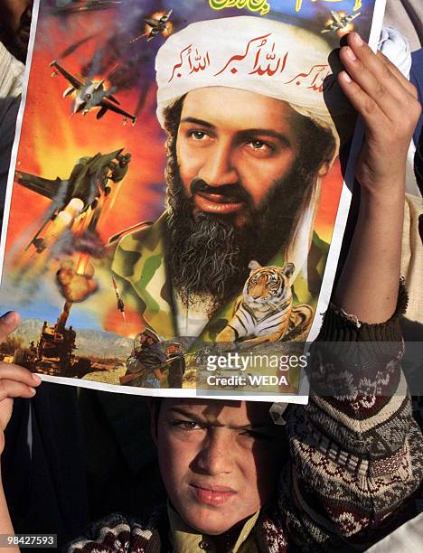 Pakistani boy holds up a portrait of suspected terrorist Osama bin Laden, leader of the al-Qaeda network, during a demonstration against the US-led...