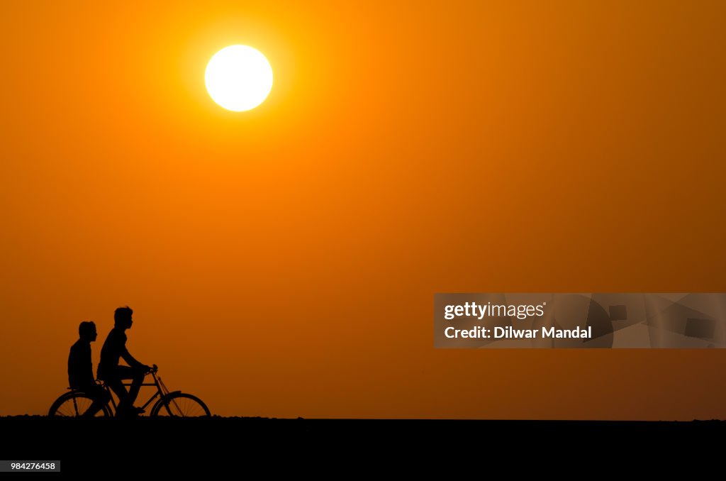 Silhouette of a cyclist men at sunset