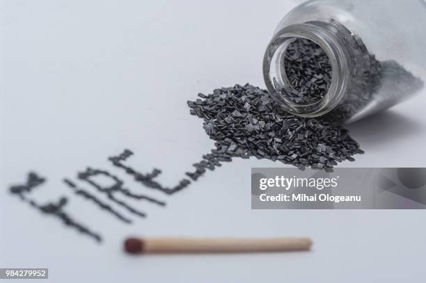 black gunpowder on white background with word fire written from powder - buskruit stockfoto's en -beelden