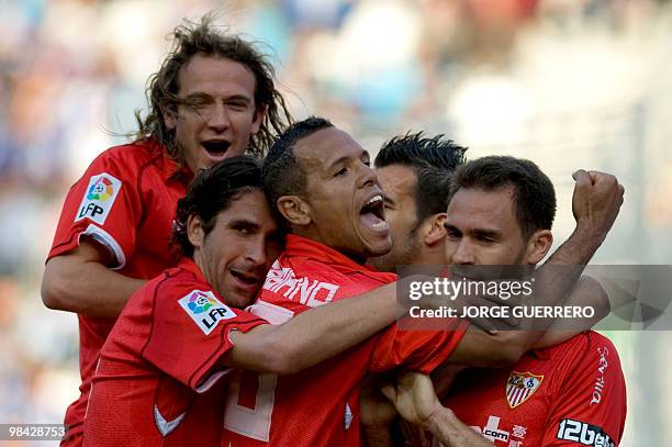 Sevilla's defender Lolo celebrates with teammates Diego Capel , Luis Fabiano and Julien Escude after scoring against Malaga during a Spanish league...