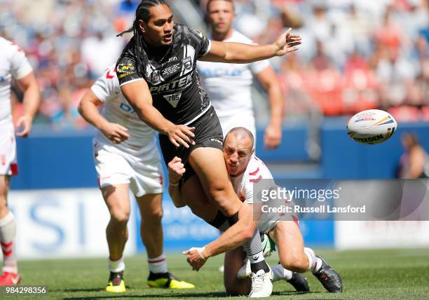 Martin Taupau of New Zealand passes the ball as he gets tackled by James Roby of England during a Rugby League Test Match between England and the New...