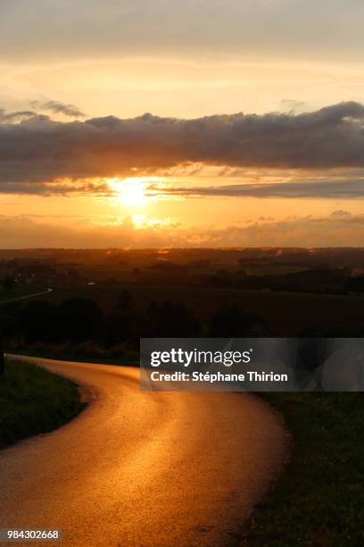 sunset on the road / coucher de soleil sur la route - coucher de soleil fotografías e imágenes de stock