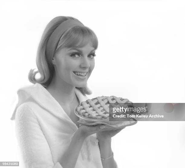 Portrait of a smiling woman as she holds a lattice-top pie, 1966.
