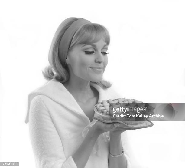 Portrait of a smiling woman as she holds a lattice-top pie, 1966.