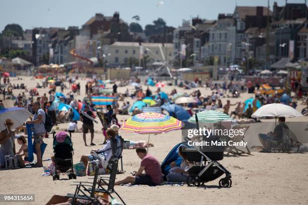 People enjoy the fine weather at the beach at Weymouth seafront on June 26, 2018 in Dorset, England. Parts of the UK are currently basking in...