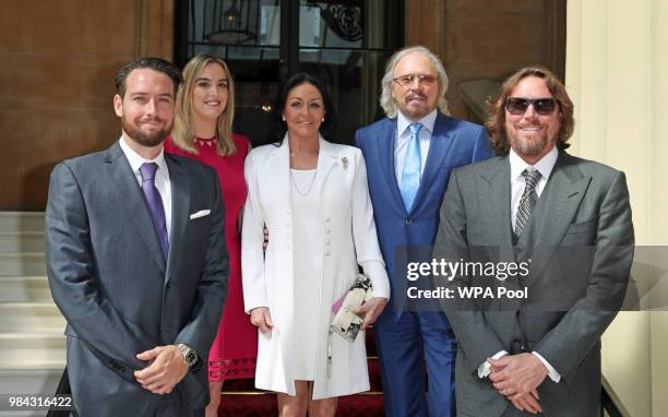 Singer and songwriter Barry Gibb poses for a photo with his wife Linda, and children, Michael, Alexandra and Ashley ahead of being knighted during an...