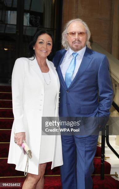 Singer and songwriter Barry Gibb poses for a photo with his wife Linda ahead of being knighted during an investiture ceremony at Buckingham Palace on...