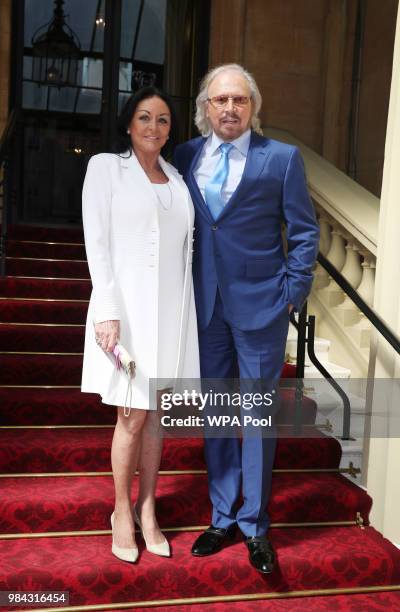 Singer and songwriter Barry Gibb poses for a photo with his wife Linda ahead of being knighted during an investiture ceremony at Buckingham Palace on...