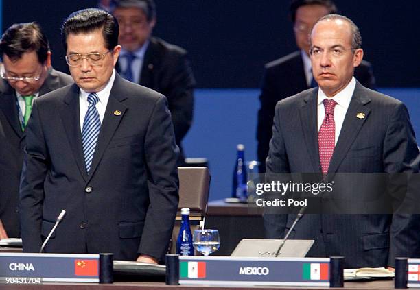 China's President Hu Jintao and Mexico's President Felipe Calderon stand for a moment in silence for recently deceased Polish President Lech...