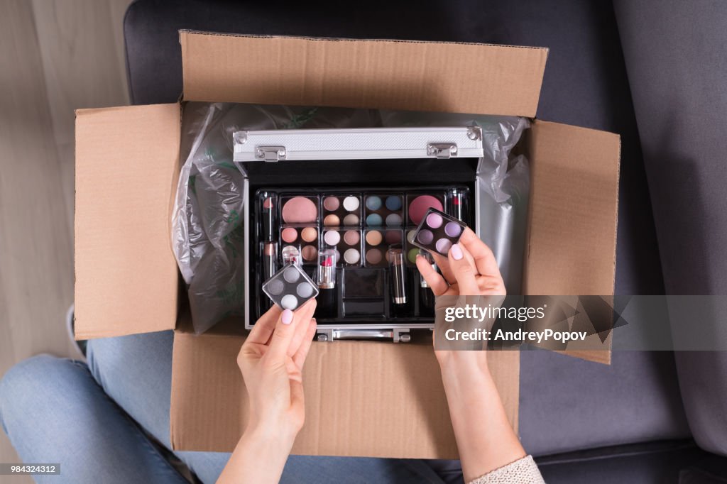 Woman Holding Cosmetics From Cardboard Box