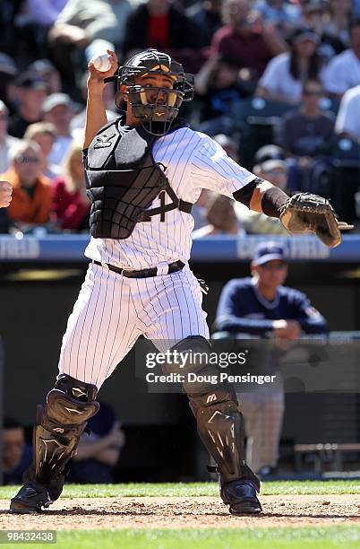 Catcher Miguel Olivo of the Colorado Rockies works behind the plate against the San Diego Padres during MLB action on Opening Day at Coors Field on...